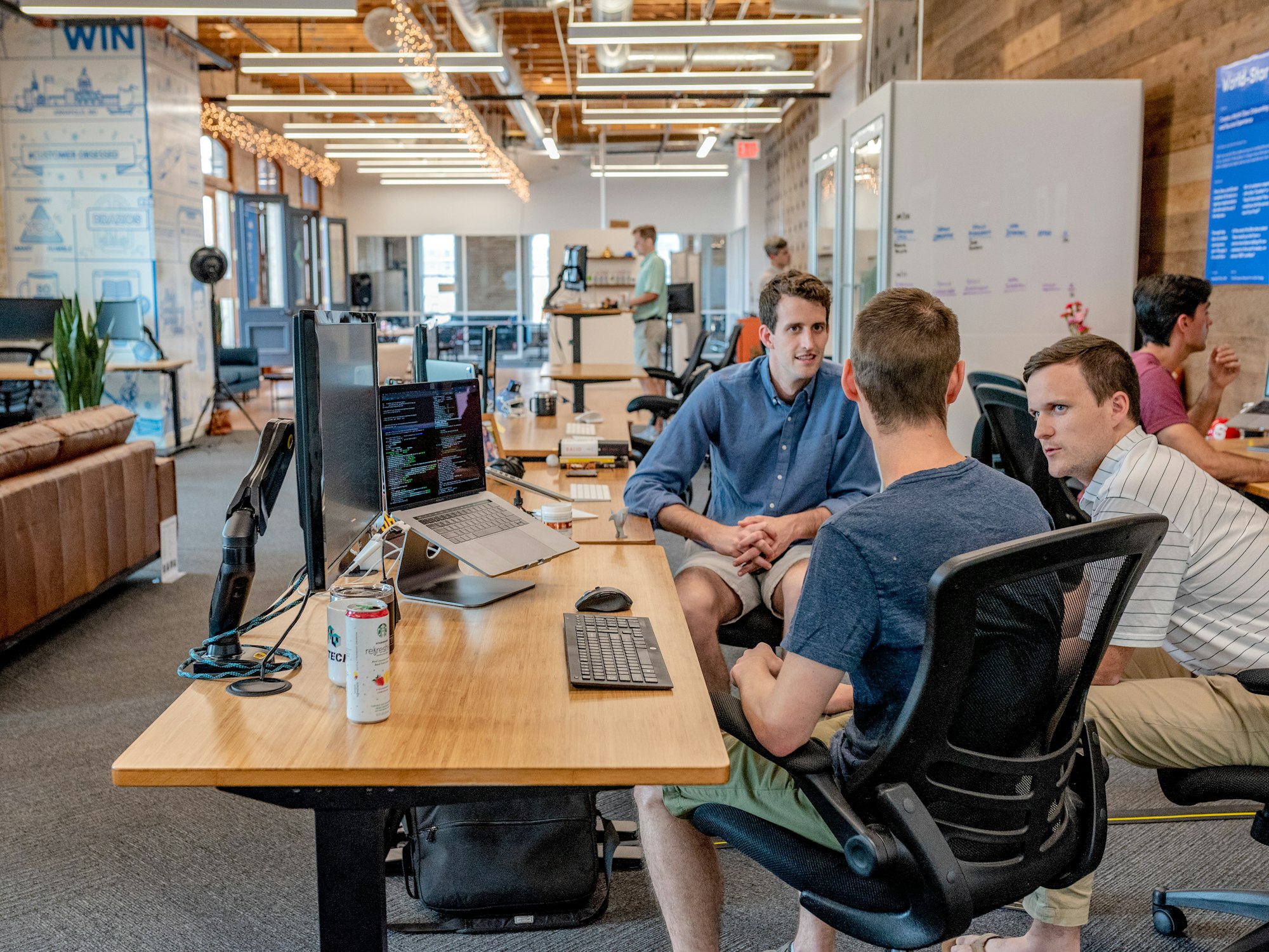 Team chatting around a desk in a bright office